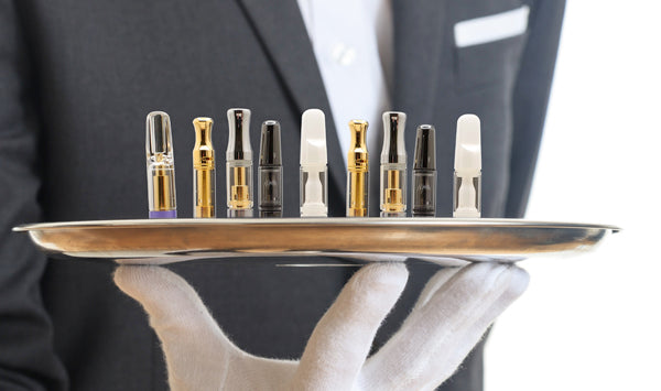 A tray of concentrate cartridge samples on a platter held by man in suit wearing a white glove
