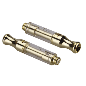Two gold 0.5 ml DM 009 510 thread vape cartridges with a yellow max fill line graduated onto the barrel and adjustable airflow ports, laying next to each other