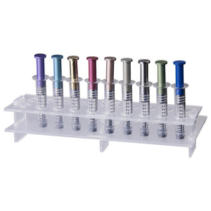 nine metal air release syringes with purple, blue, gold, red, copper, gray, silver, green, and matte blue plungers in black graduated borosilicate glass barrels with luer lock tips displayed in a tray with slots fitting one syringe each